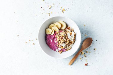 Lezzetli iştah açıcı sağlıklı diyet kahvaltısı granola, yaban mersinli yoğurt ve muz kasede servis ediliyor. Yukarıdan görüntüle. 