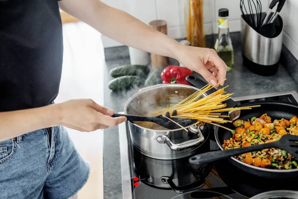 若い女性は野菜と家で新鮮なスパゲティパスタを調理します 健康的なビーガンまたはベジタリアンの概念 — ストック写真