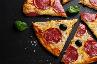 Siyah arka planda salamlı ve peynirli pizza. Yukarıdan kopyalama alanı ile görüntüle. 