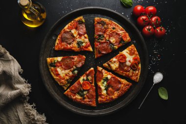 Siyah arka planda salamlı ve peynirli pizza. Yukarıdan kopyalama alanı ile görüntüle. 