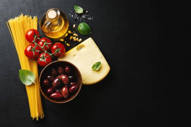 Geleneksel İtalyan yemekleri arka planında spagetti domates peyniri zeytin ve koyu arkaplanda yağ.. 