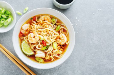 Sebzeli lezzetli Asya eriştesi ve çimento arka planda karides..