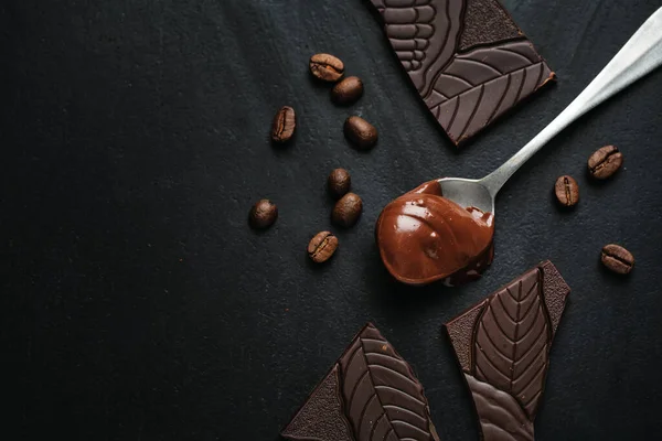 Smeltende Chocolade Lepel Met Gebroken Chocolade Koffiebonen Rond Donkere Achtergrond — Stockfoto