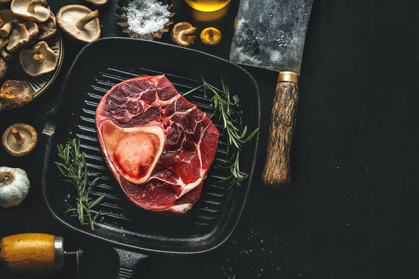 Raw meat with vegetables and spices on dark vintage background. View from above. 