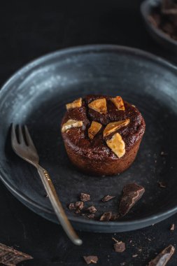 Muzlu ve çatallı, siyah tabakta çikolatalı kek. Yakın çekim.