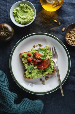 Avokado püresi ve domatesli kepekli ekmeğin üzerinde lezzetli bir sandviç. Yakın çekim.. 