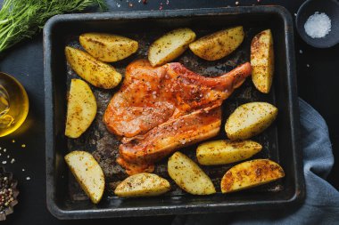 Çiğ biftekli domuz eti, çiğ patates ve fırın çeliği üzerine baharat. Üst Görünüm