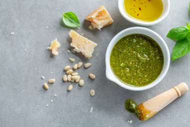 Masadaki küçük kasede pesto sosu. Yakın çekim. 