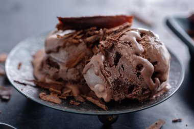 Lezzetli, iştah açıcı, çikolatalı dondurma. Koyu arkaplanda çikolata parçaları var.. 