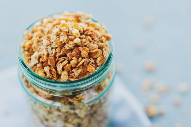 Parlak arka planda cam içinde ev yapımı meyveli müsli granola. Yakın çekim.