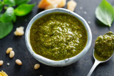 Masadaki küçük kasede pesto sosu. Yakın çekim. 