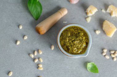 Masadaki küçük kasede pesto sosu. Yakın çekim. 