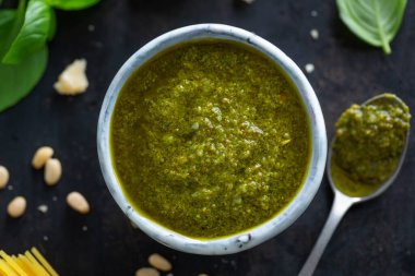 Masadaki küçük kasede pesto sosu. Yakın çekim. 