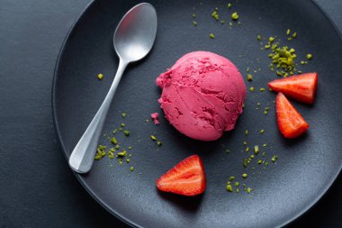 Meyveli çilekli dondurma tabakta meyve ve pistacchio ile servis edilir. Üst Görünüm. 