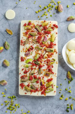 El yapımı beyaz çikolata, üzerinde de pistacchio ve parlak arka planda kuru ahududu. Üst Görünüm. 