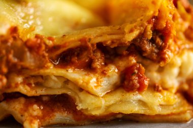 Lezzetli pişirilmiş klasik İtalyan lazanyası güveçte parlak arka planda. Yakın çekim.