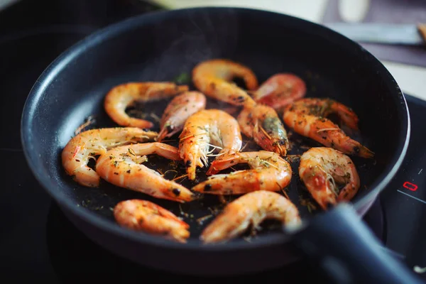 Fried shrimps in oil on pan with spices. Closeup