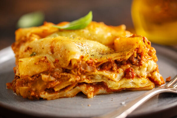 Tasty baked prepared classic italian lasagne in casserole on bright background. Closeup