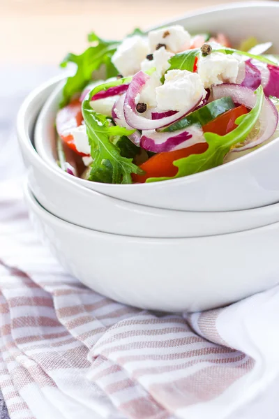 Greek salad in white ceramic bowl on textil napkin — Zdjęcie stockowe