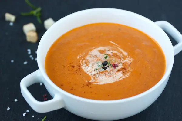 Gemüsesuppe mit sonnengetrockneten Tomaten und Sahne auf dunklem Hintergrund — Stockfoto