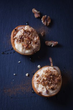 Süzme peynir, bal ve koyu arka plan üzerinde ceviz ile pişmiş armut