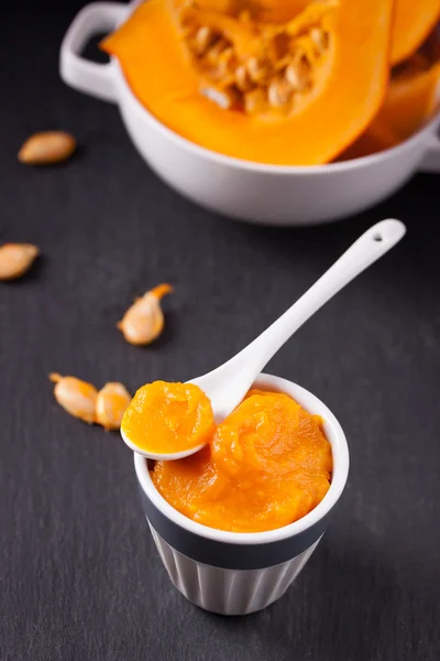 Pumpkin puree in white ceramic cup on dark background — Stock Photo, Image