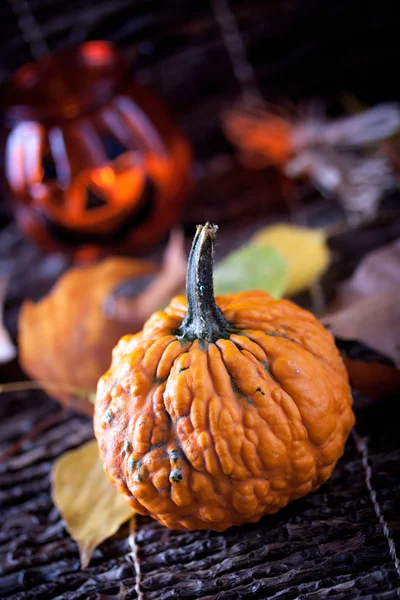Pumpkin with autumn leaves on dark wooden background Stock Photo