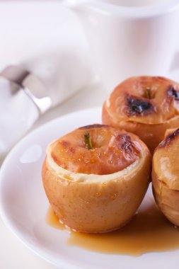 Süzme peynir, karamel ve beyaz arka plan üzerinde beyaz seramik plaka tarçın ile pişmiş elma