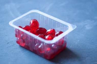 Mavi arka plan üzerinde plastik kutu konserve kiraz