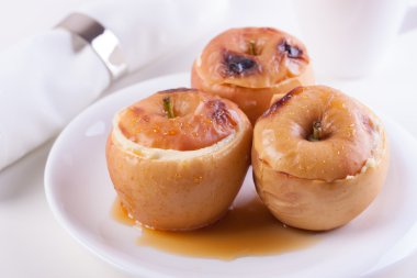 Süzme peynir, karamel ve beyaz arka plan üzerinde beyaz seramik plaka tarçın ile pişmiş elma