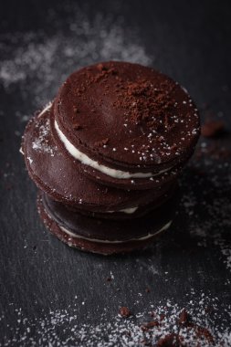 Karanlık bir arka plan üzerine krema ile ev yapımı çikolatalı kurabiye