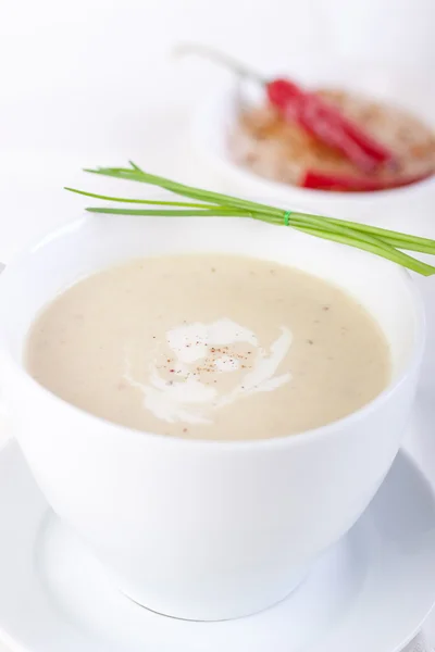 Vegetable creamy soup with cauliflower and cream in a white ceramic bowl Stock Picture