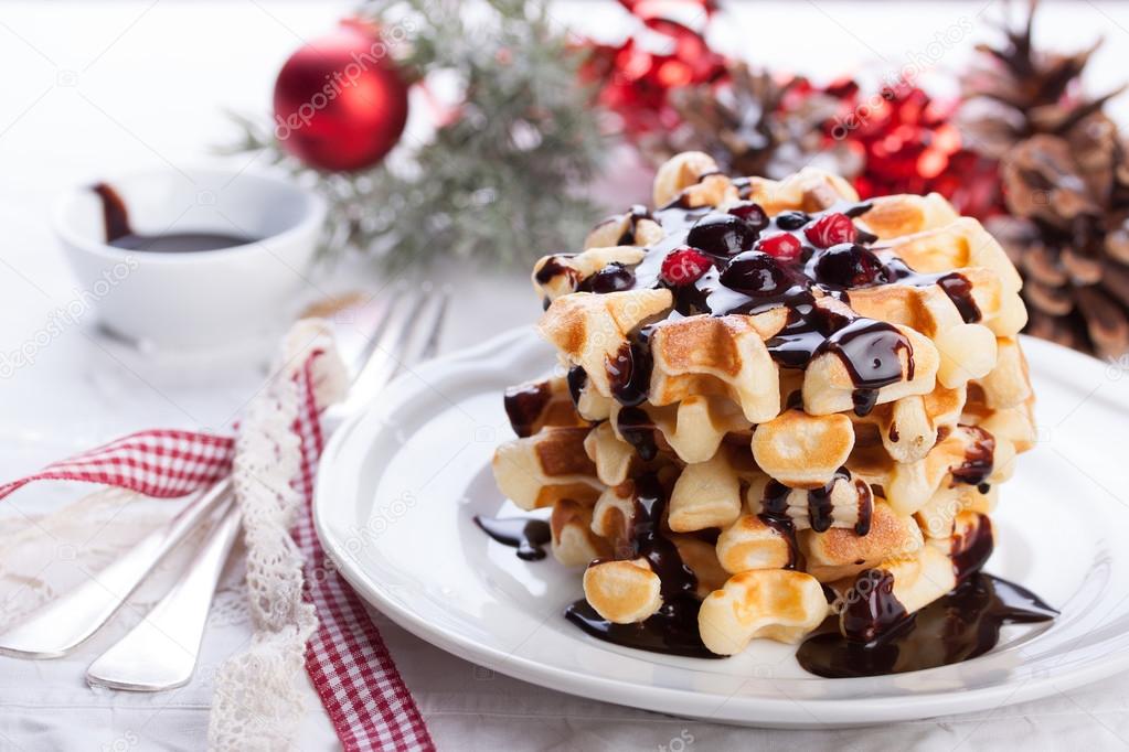 Waffles with chocolate sauce and winter berries for christmas. Closeup