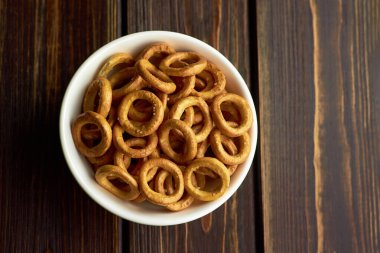 Beyaz seramik kasede Rus simitleri koyu kırsal masa arka planında, üst görünümde, boşluğu kopyala