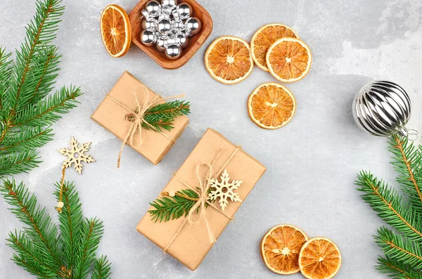 Weihnachtsgeschenkboxen mit trockenen Orangenscheiben und grünen Tannenzweigen — Stockfoto