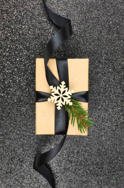 Siyah kurdeleli ve noel süslü hediye kutusu.