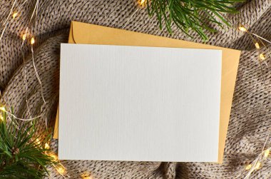 Arka planda çam ağacı dalları ve çelenk içeren tebrik kartı modeli. Fotokopi alanı olan düz bir Noel.