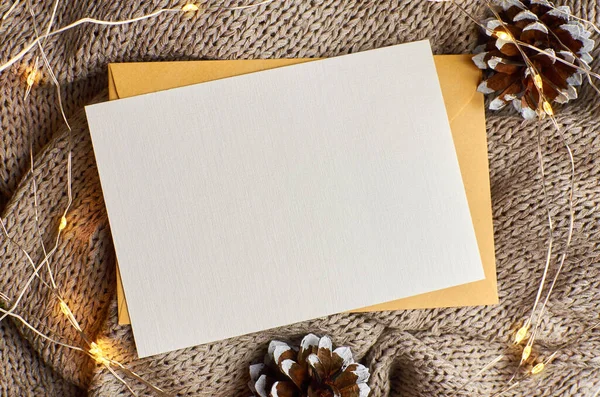 Arka planda çam ağacı konisi ve çelenk içeren tebrik kartı modeli. Fotokopi alanı olan düz bir Noel.