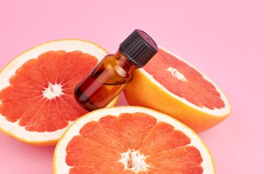 Greyfurt yağı, aromaterapi ya da pembe arka planda doğal organik kozmetik. Doğal vücut ve deri tedavisi.