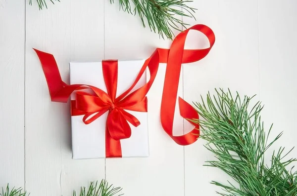 Kerstgeschenkdoos Met Rood Lint Dennenboomtakken Witte Houten Ondergrond Bovenaanzicht — Stockfoto