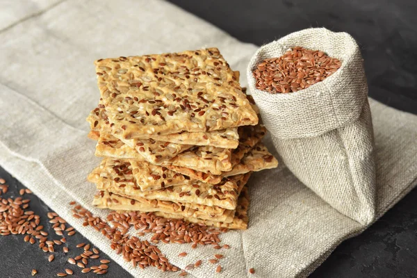 Homemade crispy gluten free crispbread with lots of seeds on linen background. Healthy snack, seed crackers.