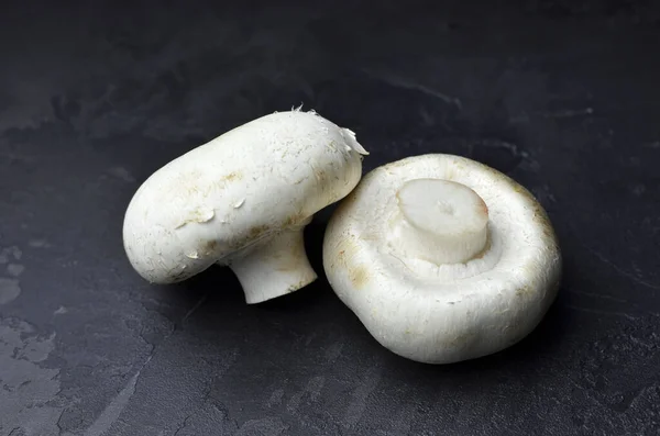 Grzyby Champignon na czarnym tle. Wegańska koncepcja żywności. — Zdjęcie stockowe