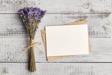 Ahşap zemin üzerinde lavanta çiçekleri olan tebrik kartı modeli, üst görünüm, boşluk kopyala