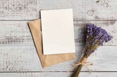 Davetiye kartı modeli ahşap arka planda lavanta çiçeği buketi, üst görünüm, boşluk kopyala