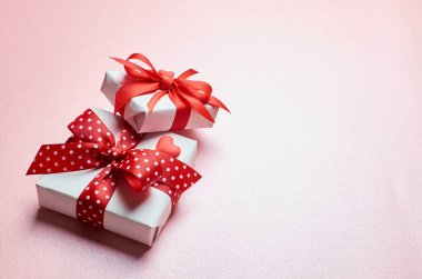 Sevgililer Günü hediye kutuları pembe arka planda küçük bir kalp