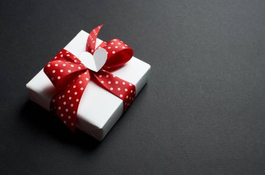 Sevgililer Günü hediye kutusu, siyah arka planda kalple süslenmiş.