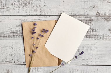 Ahşap arka planda kuru lavanta çiçekleri ve zarf içeren tebrik kartı modeli