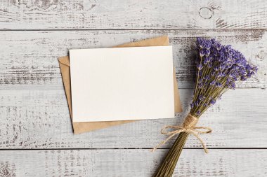 Fotokopi alanı ve ahşap arka planda lavanta çiçekleri olan davetiye kartı