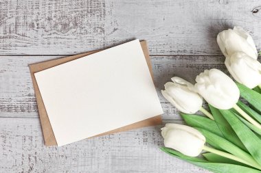 Ahşap zemin üzerinde lale çiçekleri olan tebrik kartı modeli, üst görünüm, boşluk kopyala