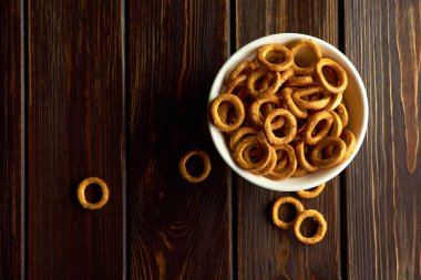 Beyaz seramik kasede küçük buğday simitleri koyu kırsal masada, üst görünümde, boşluğu kopyala